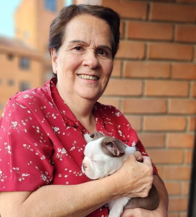 Margarita Rosa Posada directora de logística ayudas apra todos y fundacion todos podemos ayudar Margarita Rosa Posada foto vestido rojo cargando a un perro