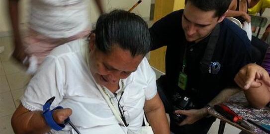 felipe con mujer con mano amputada usando correa que el ayuda a escribir